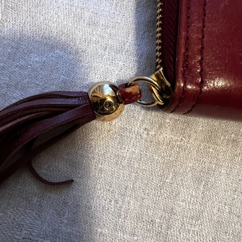 Vintage Monet zip around wallet with tassel on zipper. Maroon in color.
